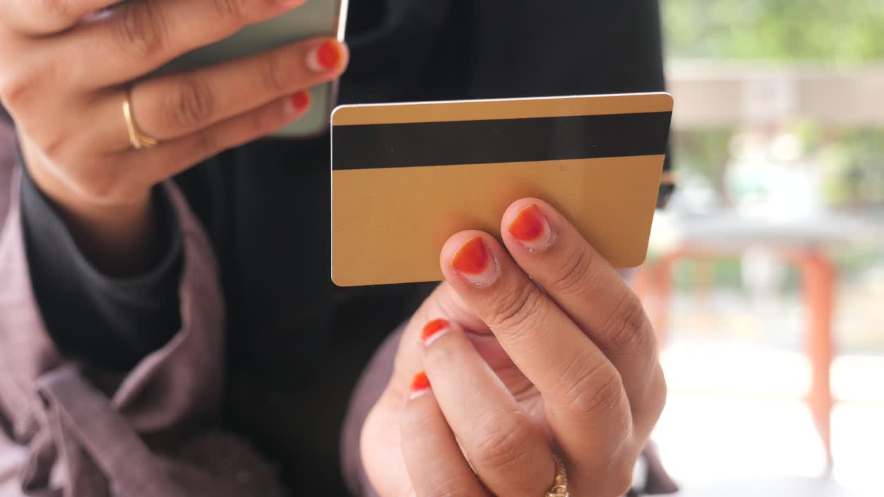 mujer que utiliza tarjeta de crédito y teléfono móvil para comprar en línea