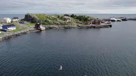 touristen, die an einem schönen tag in idyllischer umgebung in nordnorwegen paddeln, insel lofoten, sup-board