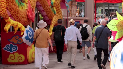 personas caminando hacia una gran estatua de dragón