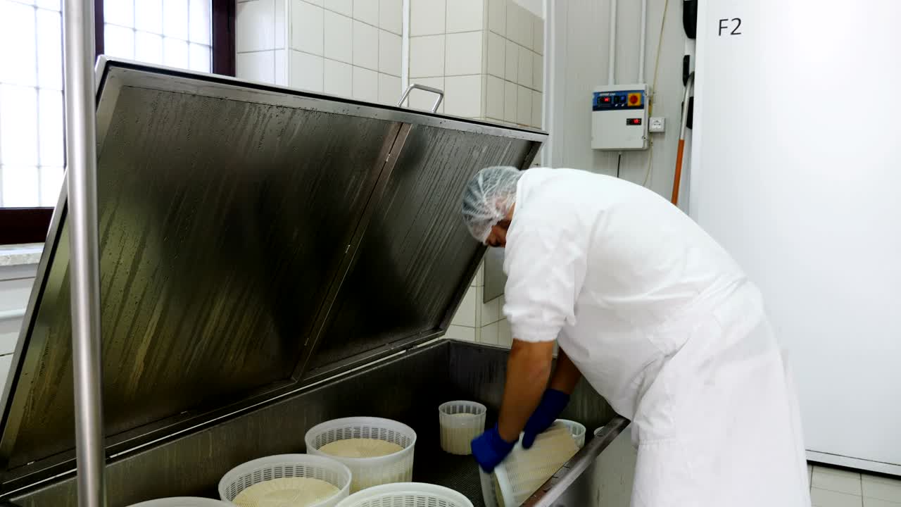 fábrica de queso de queso: operador comprobando los moldes de queso