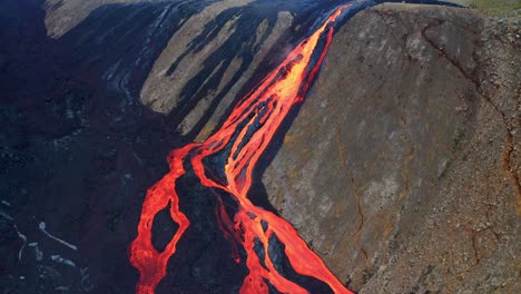 aerial view of a huge stream of lava flowing down the mountain near fagradalsfjall volcano in iceland