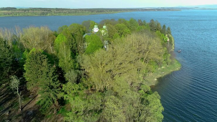 полет над островом сланица в оравской приеградской плотине с барочной церковью, словакия