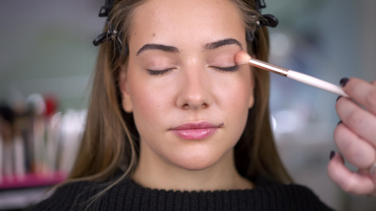 Woman applying eyeshadow with a brush, close-up
