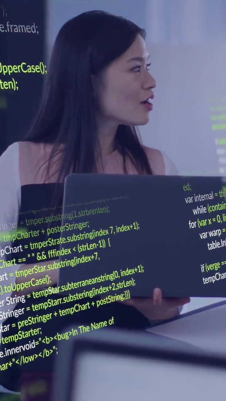 Vertical video: Woman dev shifting gaze after peer cue, reviewing code on laptop with green overlay