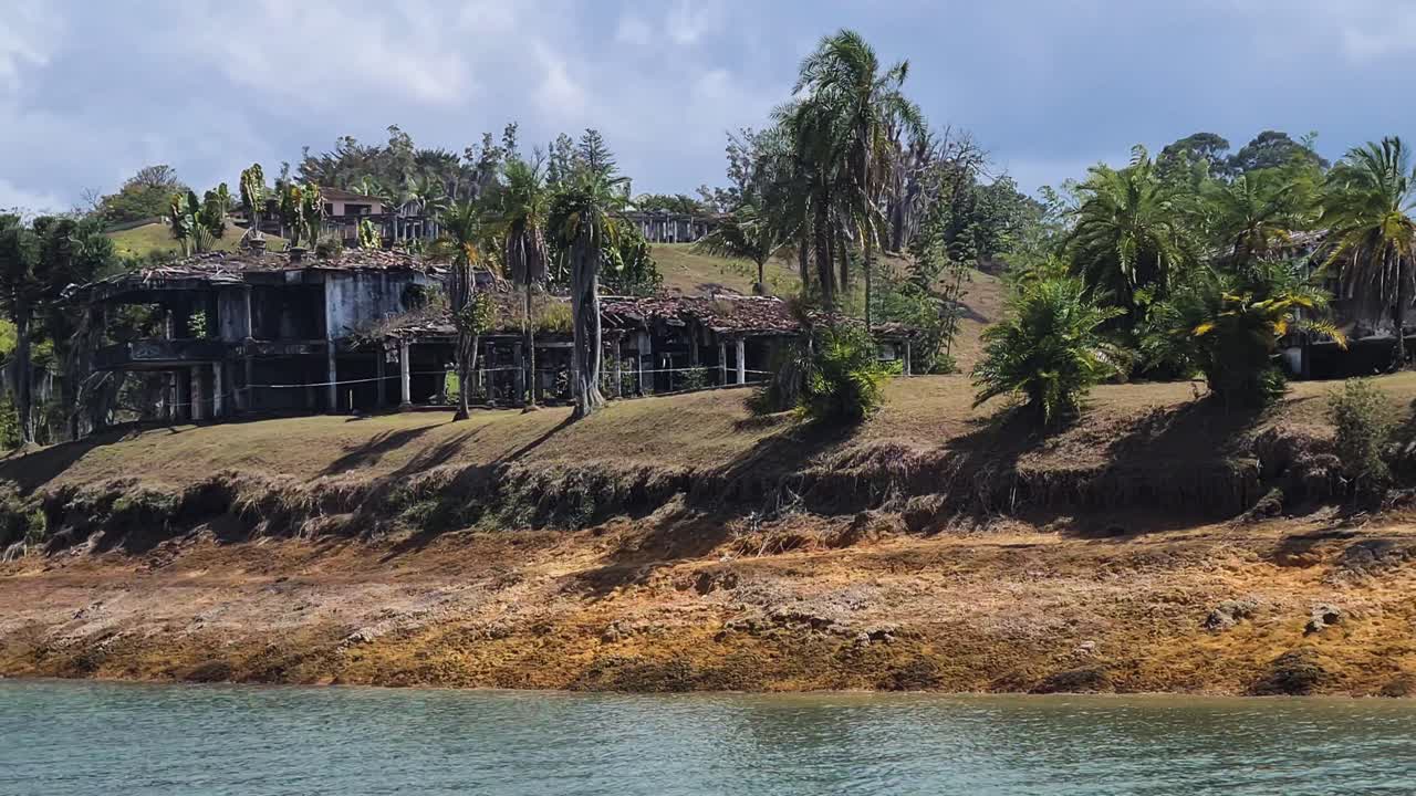 casas abandonadas en la orilla de un lago tropical