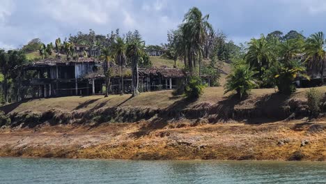 casas abandonadas en la orilla de un lago tropical