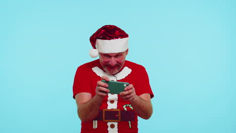 worried man in new year t-shirt and hat enthusiastically playing racing video games on mobile phone