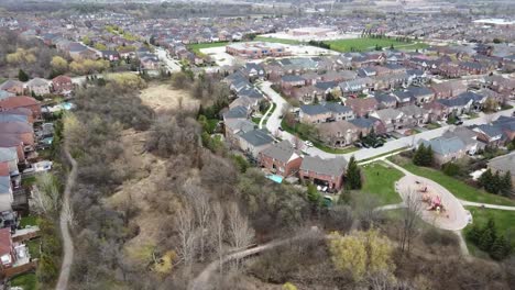 vista aérea dando vueltas sobre el patio de recreo suburbano en un día de primavera nublado