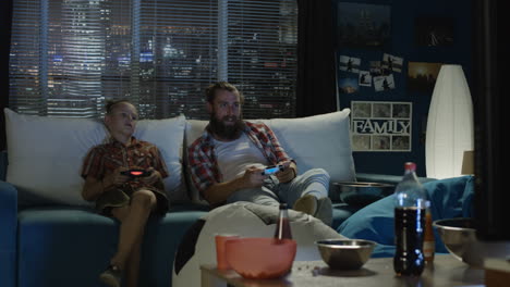 father and son playing video games at home