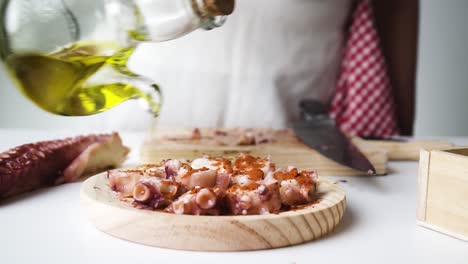 Shot-of-a-person-pouring-some-olive-oil-on-the-octopus-to-temper-and-prepare-it-for-cooking