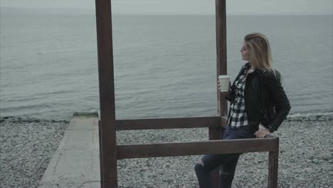 mujer con café en la playa