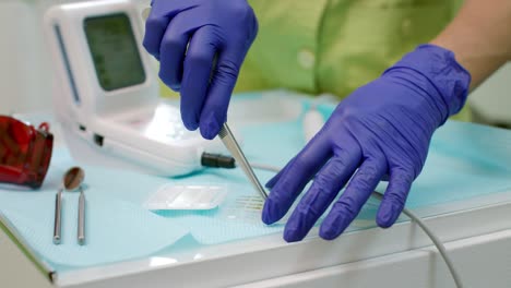 stomatólogo preparando herramientas de odontología. manos del dentista preparando la turbina dental