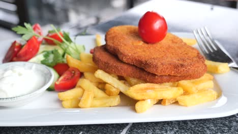 delicious breaded chicken cutlets with fries and salad