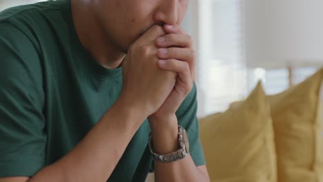 asian man sitting at sofa thoughtful fatigue looking away at home.