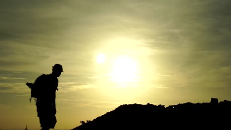 silhouette of travel hiking man on the rock in slow motion