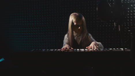 young girl playing piano in a recording studio