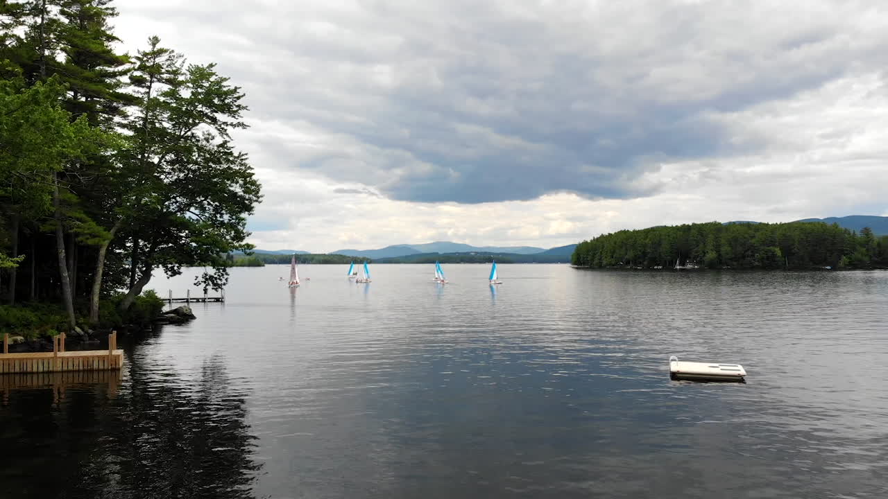 Low drone flyover of summer New Hampshire lake shore real estate
