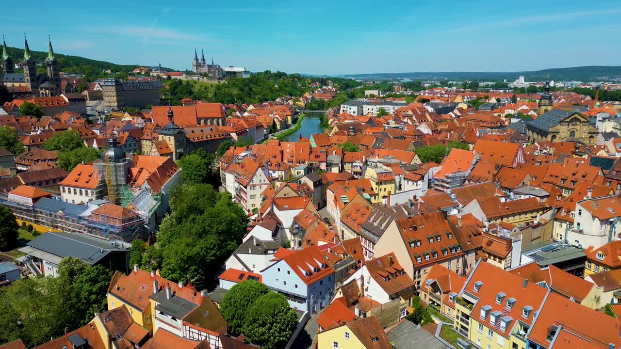 Video aereo 4K con drone di gru edili vicino alla Cattedrale di Bamberga e all'Abbazia di Michaelsberg lungo il fiume Regnitz, nella zona storica della città vecchia di Bamberga, Germania