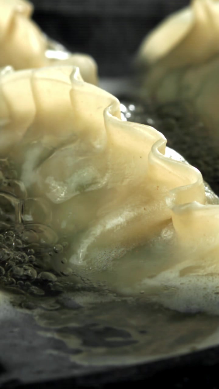 Close-up of Gyoza Dumplings Frying in a Sizzling Pan