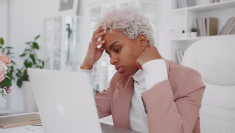 joven trabajadora de oficina afroamericana mira la computadora portátil con cara infeliz