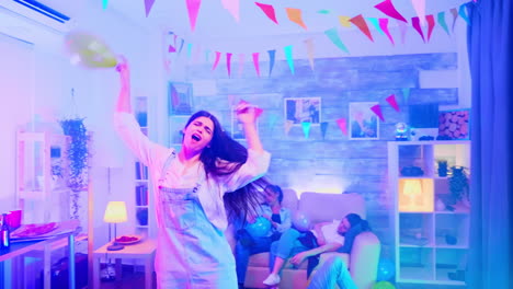 excited young woman with balloon dancing at a party