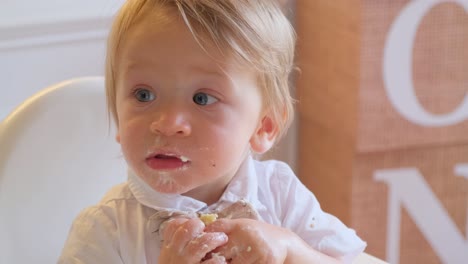 a baby boy joyfully explores food and plays creatively with sand. this heartwarming video shows a baby boy joyfully enjoying mealtime in his high chair, playfully exploring food with a fork and his hands