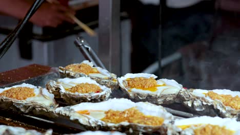 oysters being grilled at a street food stall