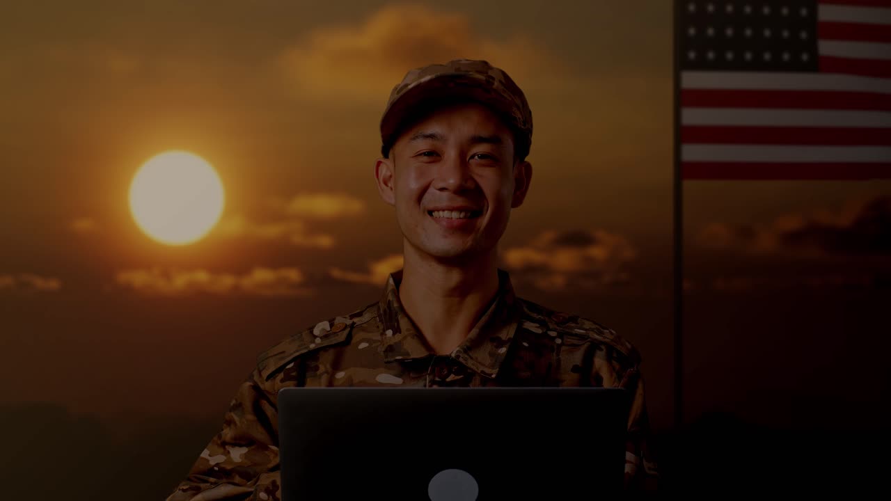 Soldato sorridente che lavora al laptop al tramonto