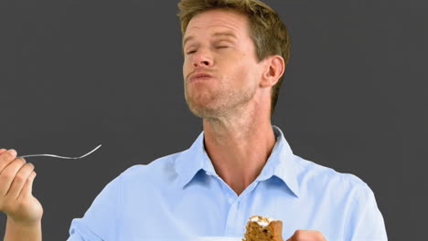 man savouring a delicious cake on grey screen