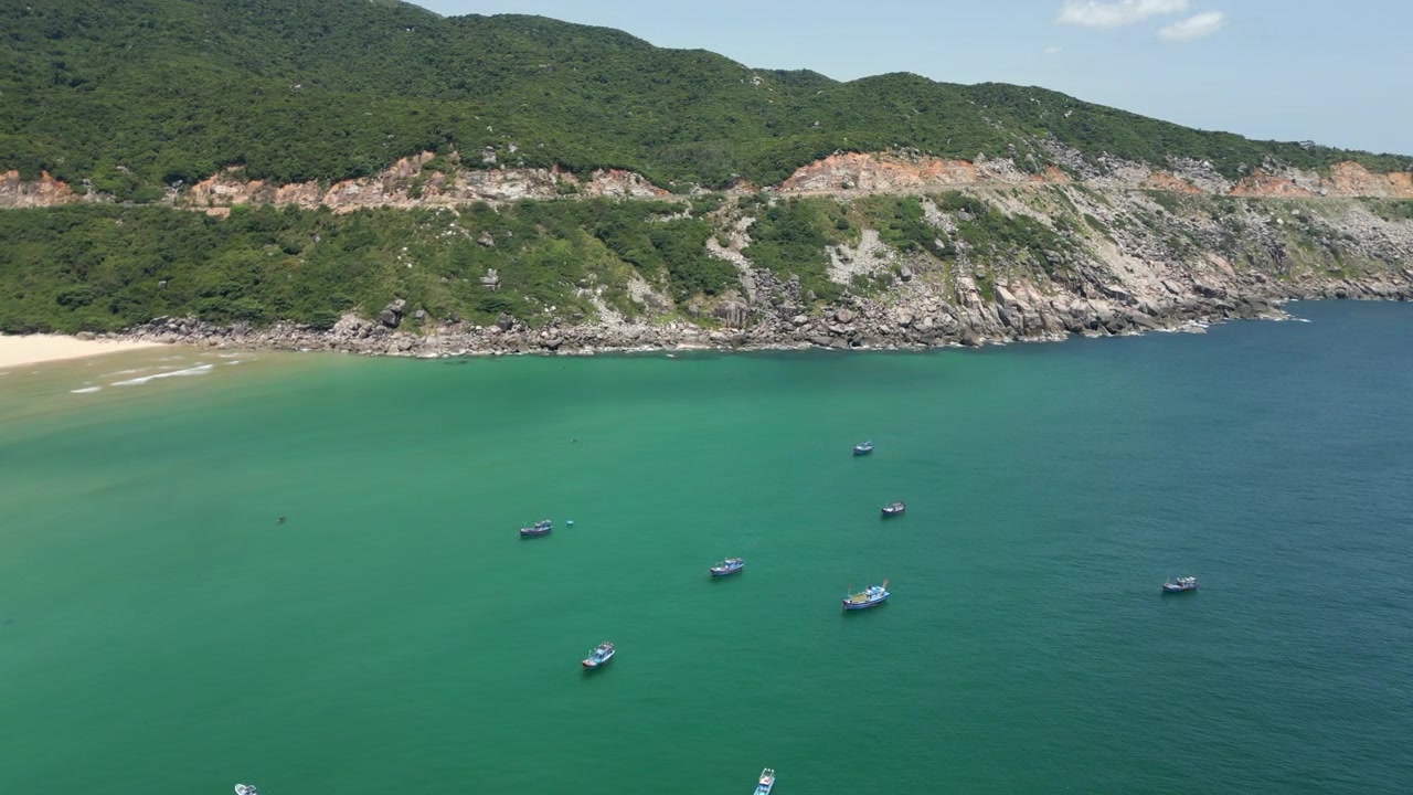 Barche da pesca galleggiano su acqua calma sulla spiaggia di Bai Mon, provincia di Dak Lak, Vietnam. Tracciamento drone in 4K 30FPS