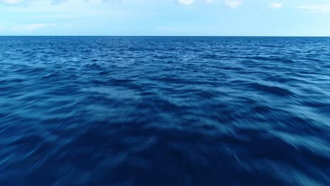 Low-flying-aerial-dolly-above-deep-blue-caribbean-water,-no-people