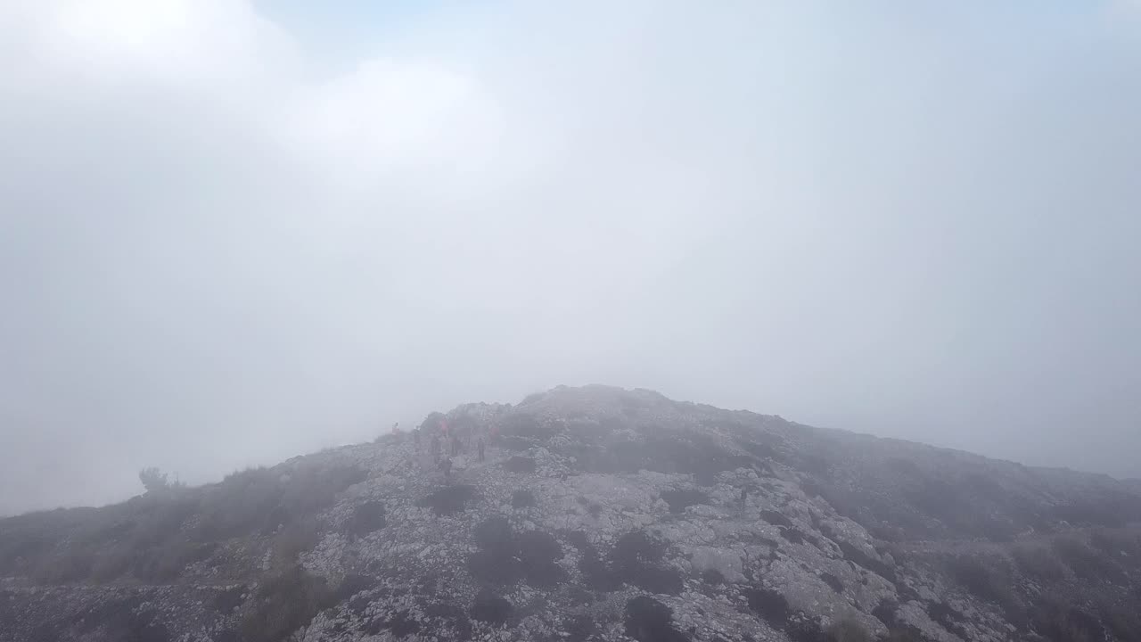 Aerial shot through the clouds towards Puig Gros summit, Mallorca, Spain