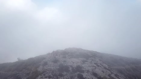 aerial shot through the clouds towards puig gros summit, mallorca, spain