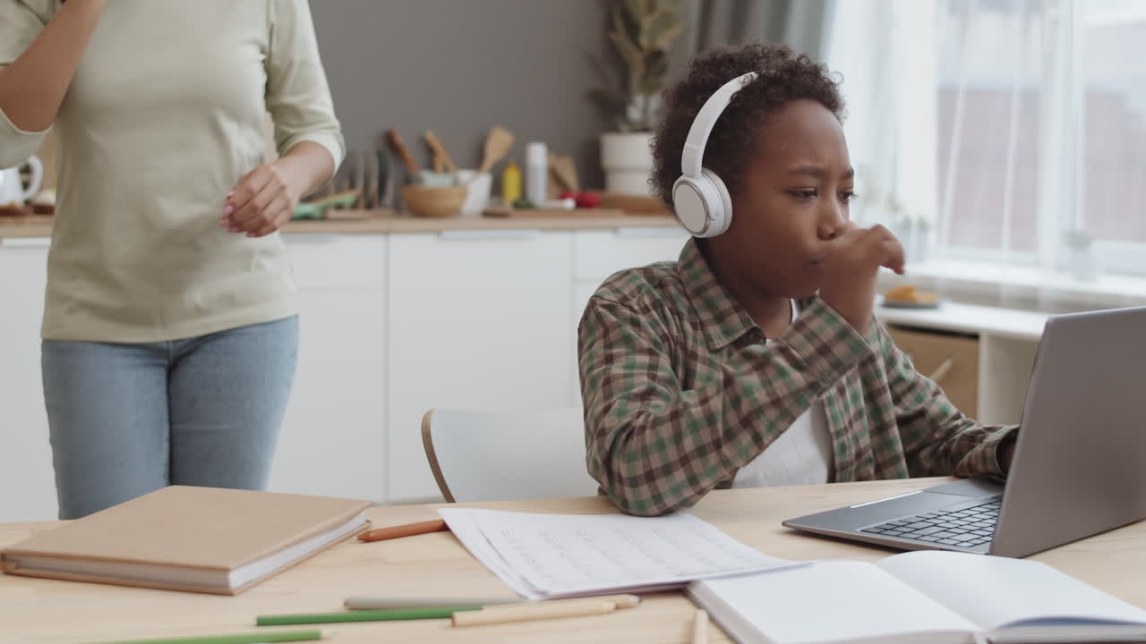 Mother helping son with online learning