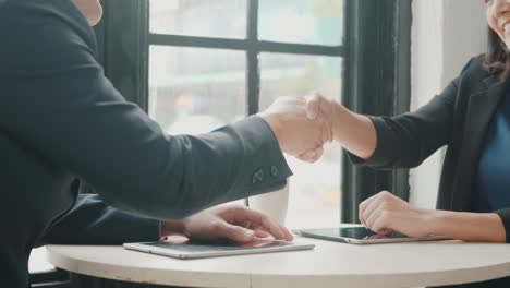 businessman and woman shaking hands after successful meeting