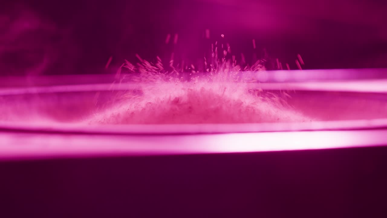 Close-up Bubuk Magenta Menari di Kerucut Speaker yang Bergetar.
