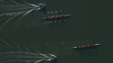 Scenic-aerial-tracking-shot-of-two-rowing-crews-with-accompanying-boats