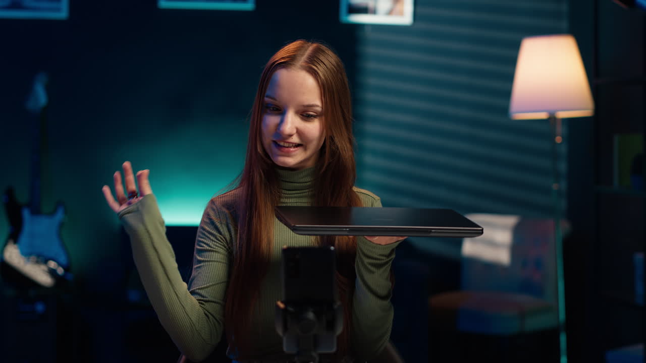 십대가 회사에서 후원한 노트북을 추종자들에게 제시하고, 드폰으로 촬영하고 있습니다.