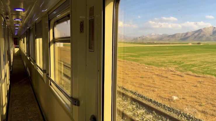 Train view landscape watching unique perspective Iran nature scenic mountain plain farm field meadows rustic village green journey countryside travel window frame motion movement passing rail serene