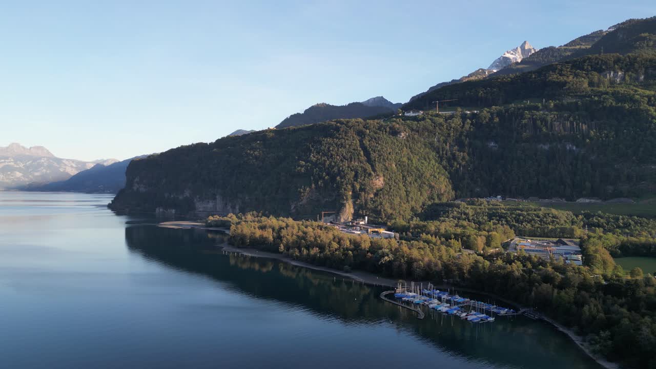 una maravillosa vista panorámica del lago walensee con ondas de agua azul cristalino, un pequeño puerto, y un telón de fondo de montaña en un clima fantástico