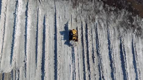 birds eye view drone shot snowplow clearing and moving snow in canada