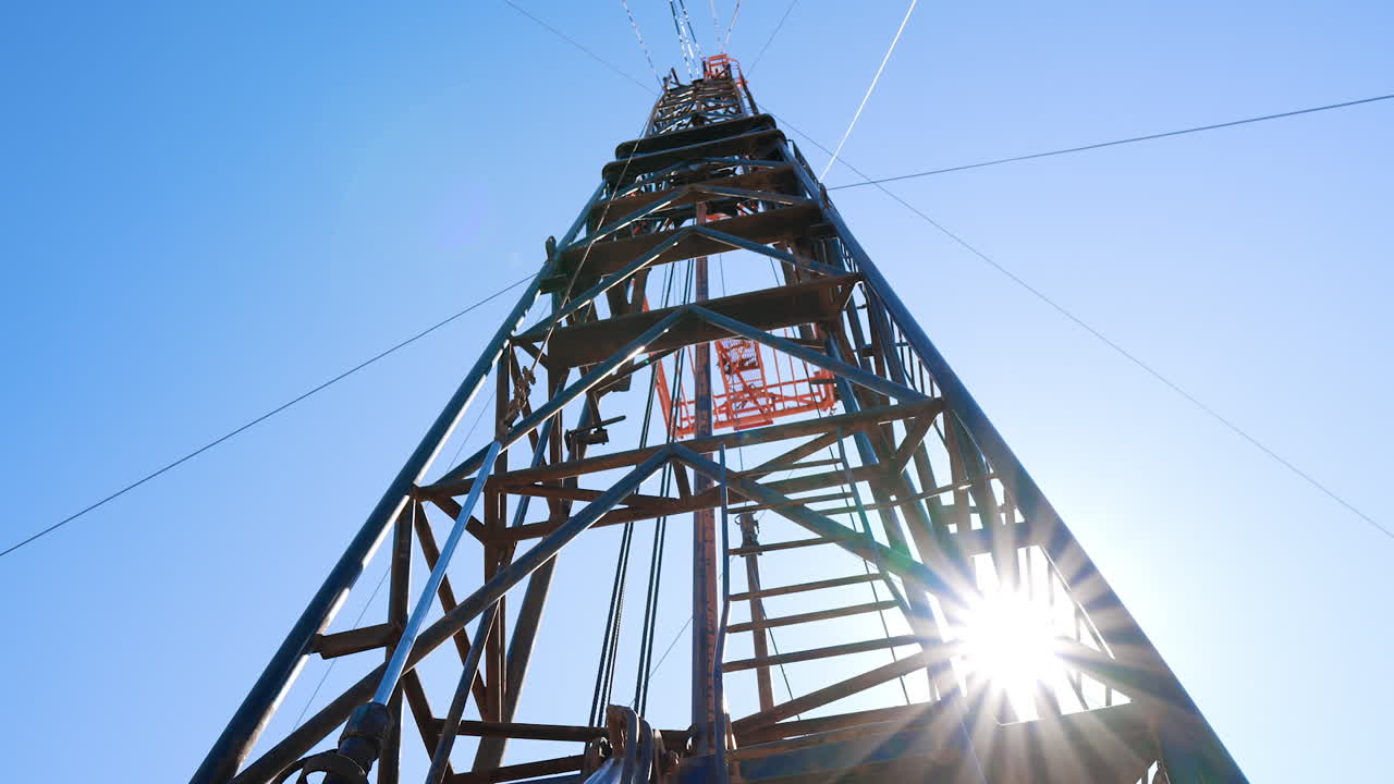 Tower for drilling oil or gas. Low angle view at boer derrick for natural resources extraction.