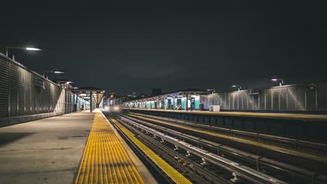 timelapse of train arriving at night in astoria, queens, new york city