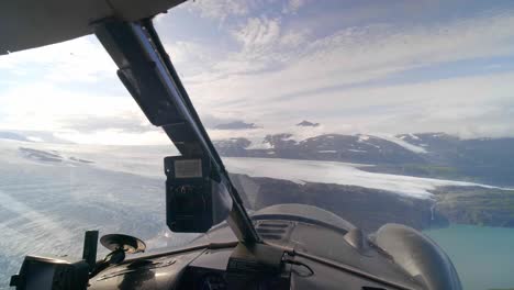 airplane cockpit pov of glaciers and mountains of alaska on sunny day