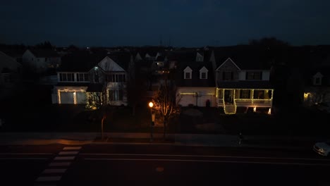 suburban neighborhood with christmas lights at night