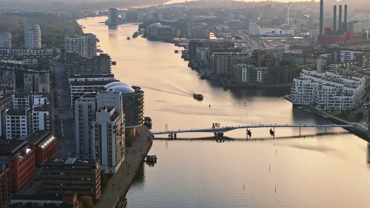 Aerial drone view of people moving on the Quay Bridge across the port of Copenhagen, Denmark in the evening