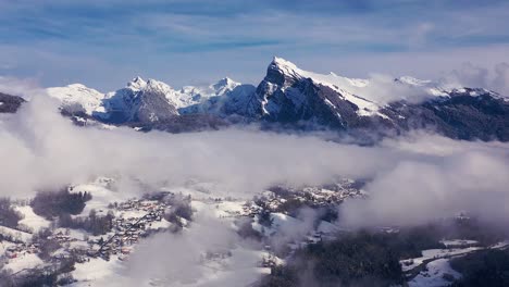 un hiperlapso aéreo por encima de las nubes del valle cubierto de nieve de giffre en haute-savoie con el pico criou al fondo, alpes franceses