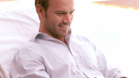 Man-using-laptop-on-sun-lounger