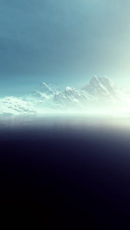 snowy mountain range reflected in a calm lake