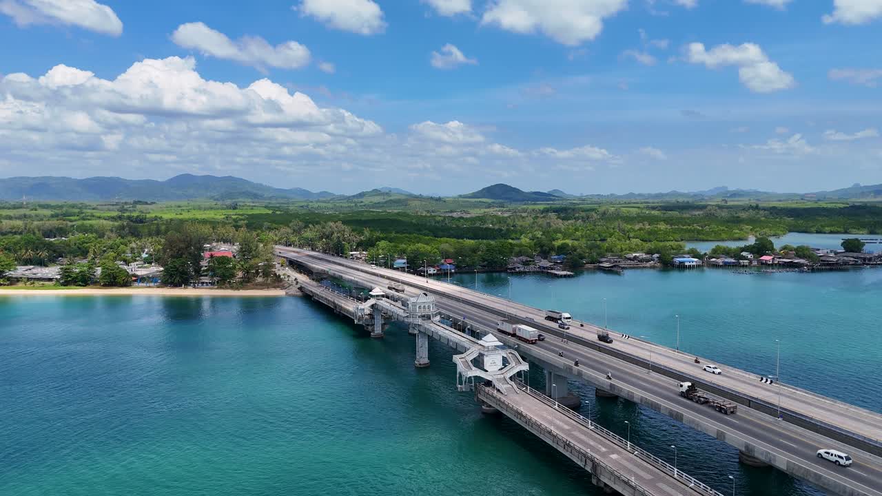 태국 푸켓에 있는 사라신 다리가 은 하늘 아래 푸르키즈색 물을 가로질러 펼쳐져 있는 모습이 드론으로 촬영된 영상입니다.